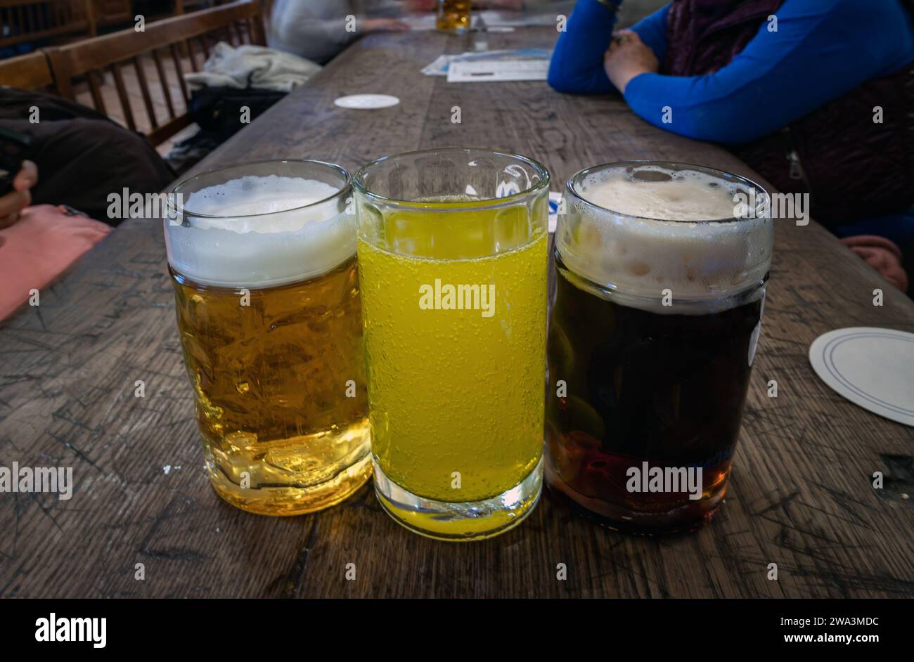Tre bicchieri di diversi tipi di birra fredda e gustosa sono in fila su un tavolo di legno in un ristorante. Tavolo per la compagnia degli amici, spazio per testo, Sele Foto Stock