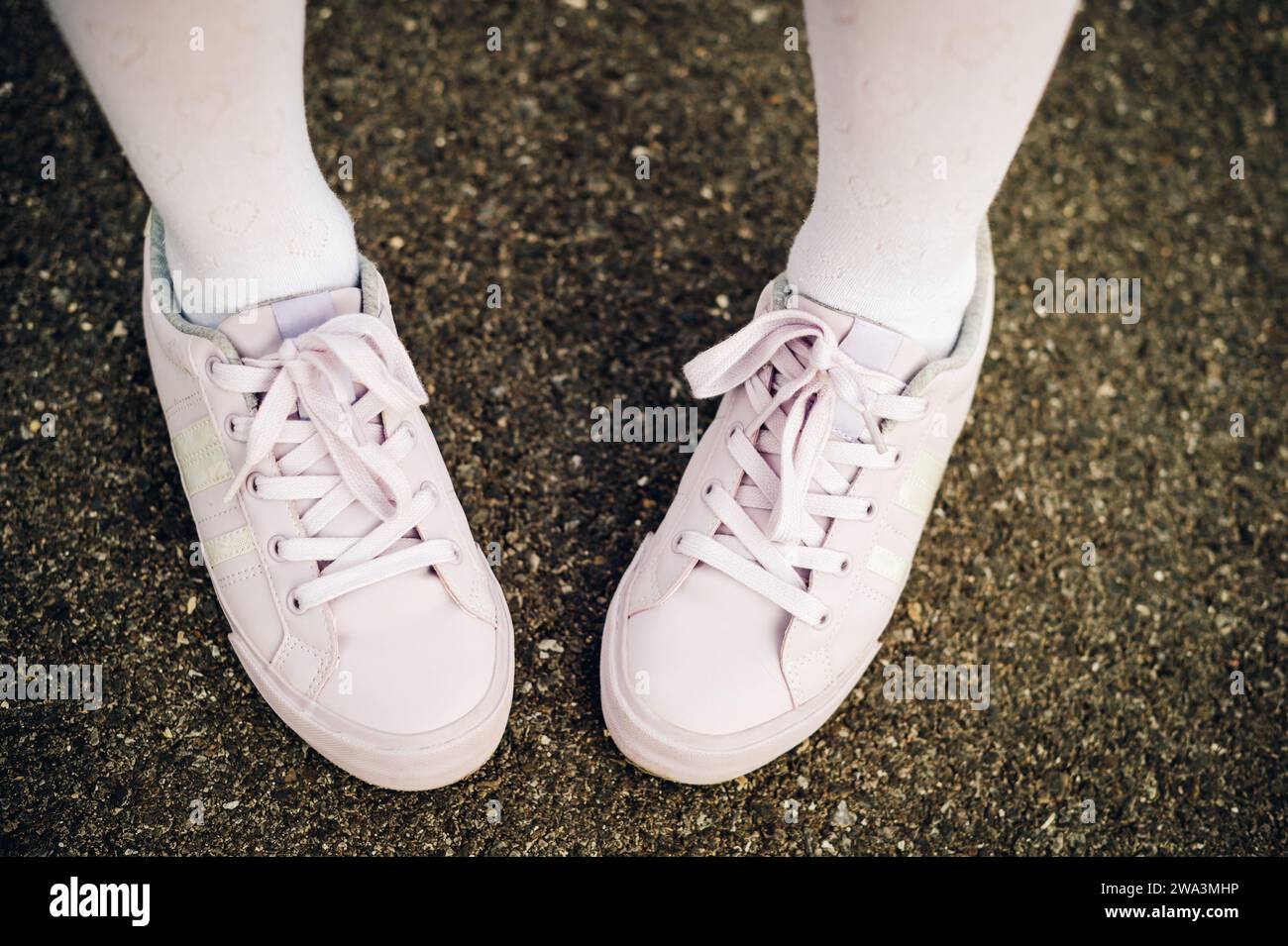 Scarpe sportive con lacci viola e alla moda sui piedi dei bambini Foto Stock