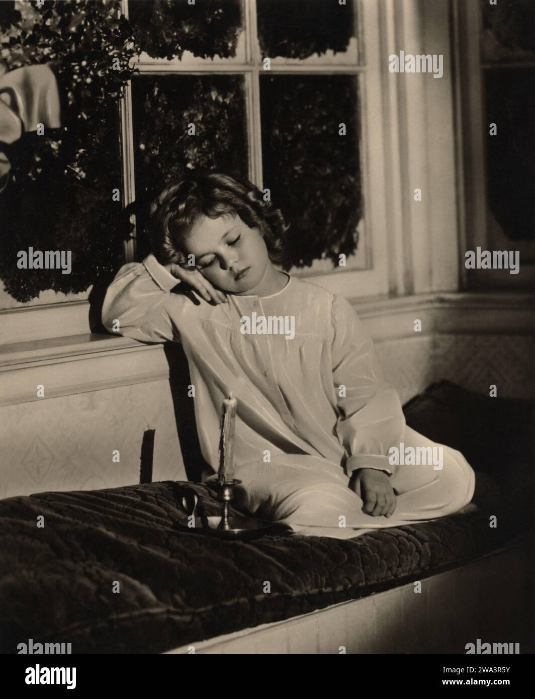 1936 c., USA : la celebrata attrice bambina SHIRLEY TEMPLE ( 1928 - 2014 ) in tempo natalizio aspettando Babbo Natale, pubblicità ancora . Fotografo sconosciuto . - NATALE - NATALE - CINEMA - ritratto - boccoli - riccioli - riccioli - bambina bambino prodigio - finestra - sogno - in attesa di BABBO NATALE - STORIA - FOTO STORICHE - candela - bugia - candela - candelabro - camicia da notte - abito da notte - BAMBINO - BAMBINI - INFANZIA - INFANZIA - NOTTE -- Archivio GBB Foto Stock
