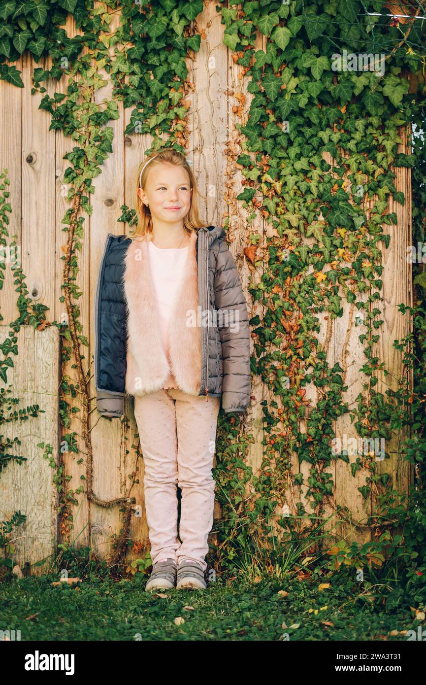 Ritratto all'aperto di adorabile bambina di 6-7 anni che indossa una calda giacca imbottita Foto Stock