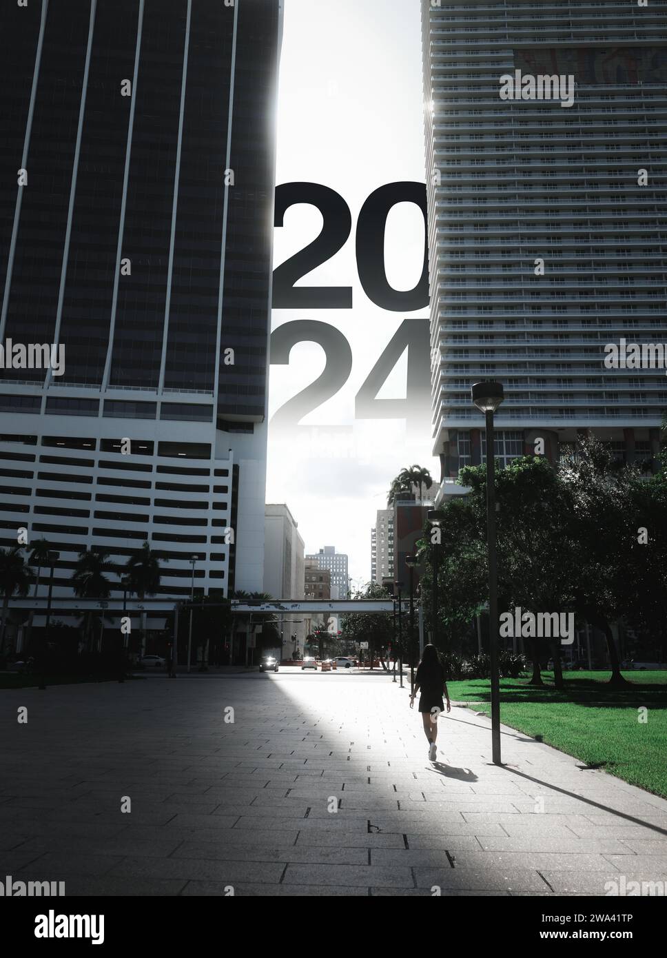 Capodanno 2024 Fotografia cinematografica. Donna che cammina tra gli edifici del centro di Miami verso i numeri 2024. Foto Stock