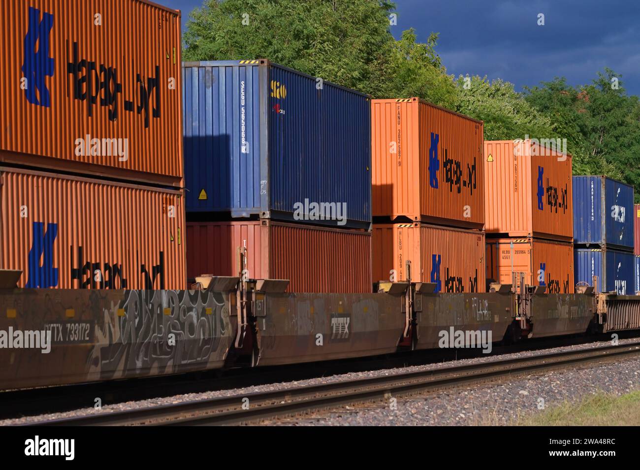 Glen Ellyn, Illinois, USA. Il sole del tardo pomeriggio illumina i container su un treno merci intermodale della Union Pacific Railroad diretto a Chicago. Foto Stock