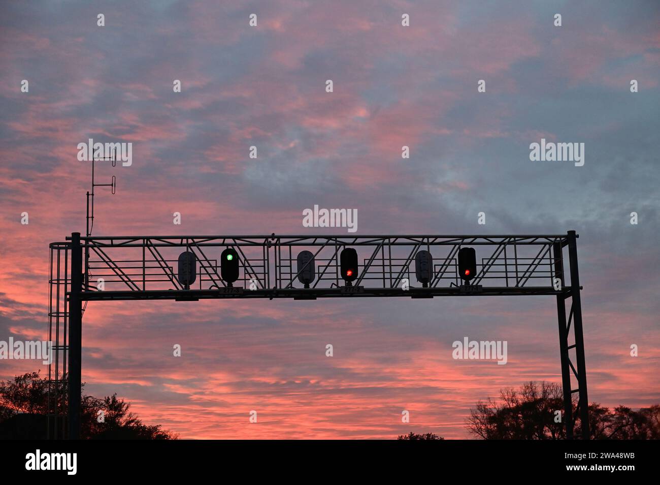 Winfield, Illinois, USA. Un ponte di segnale che mostra diverse autorizzazioni di colore sopra una linea principale a tre binari nel nord-est dell'Illinois. Foto Stock