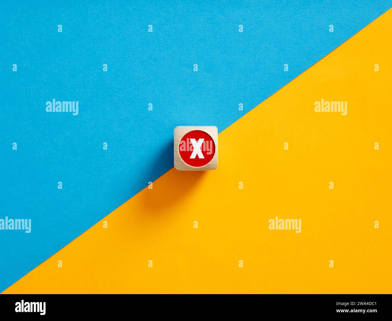 Simbolo a croce con segno X su un pulsante a cubo di legno. Disaccordo tra le parti. Rifiuto o annullamento. Divieto di attraversamento. Foto Stock