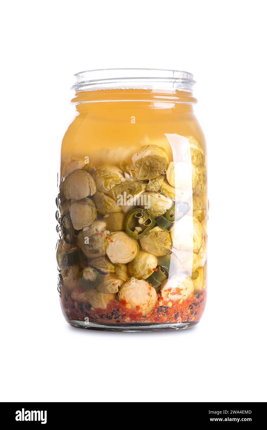 Cavoletti di Bruxelles, fatti in casa e fermentati in un vaso di vetro. Germogli di Bruxelles e peperoncini verdi fermentati da batteri lattici. Foto Stock