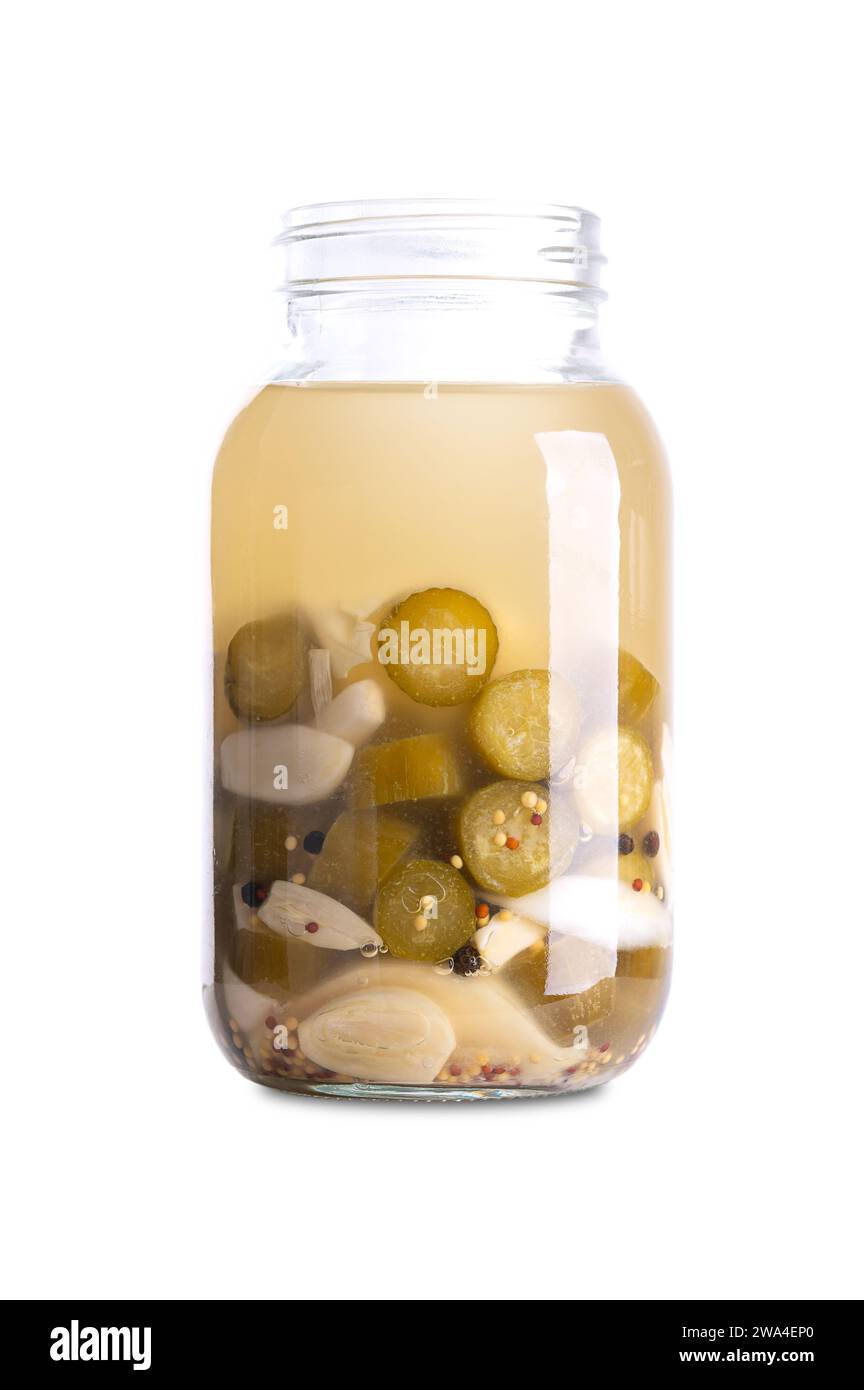 Cetrioli all'aglio, fatti in casa e fermentati in un vaso di vetro. Cetrioli a fette e spicchi d'aglio fermentati da batteri lattici. Foto Stock