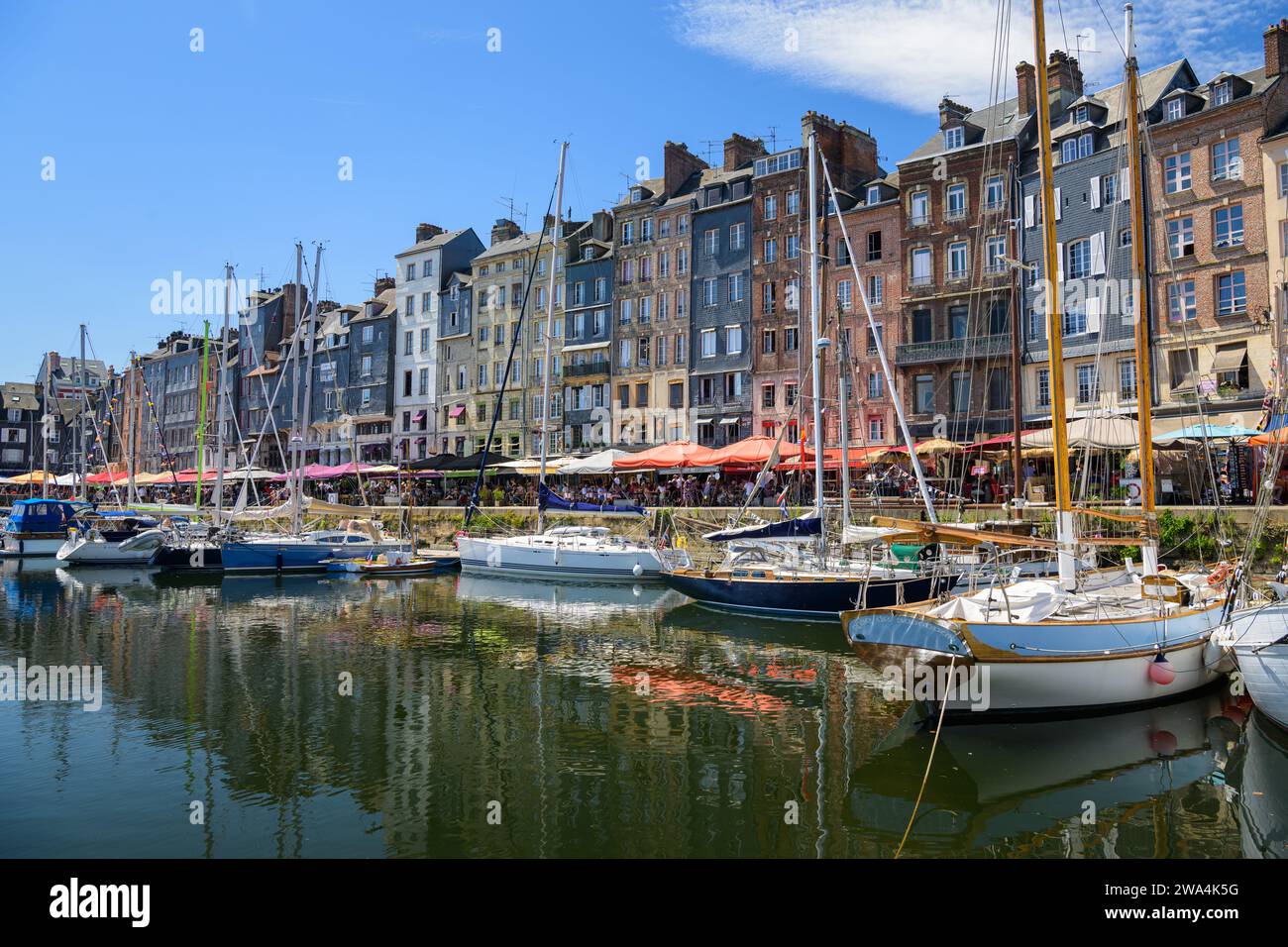 Honfleur, Francia - 24 luglio 2022: Il vecchio porto di Honfleur in una giornata di sole in estate, cielo blu Foto Stock