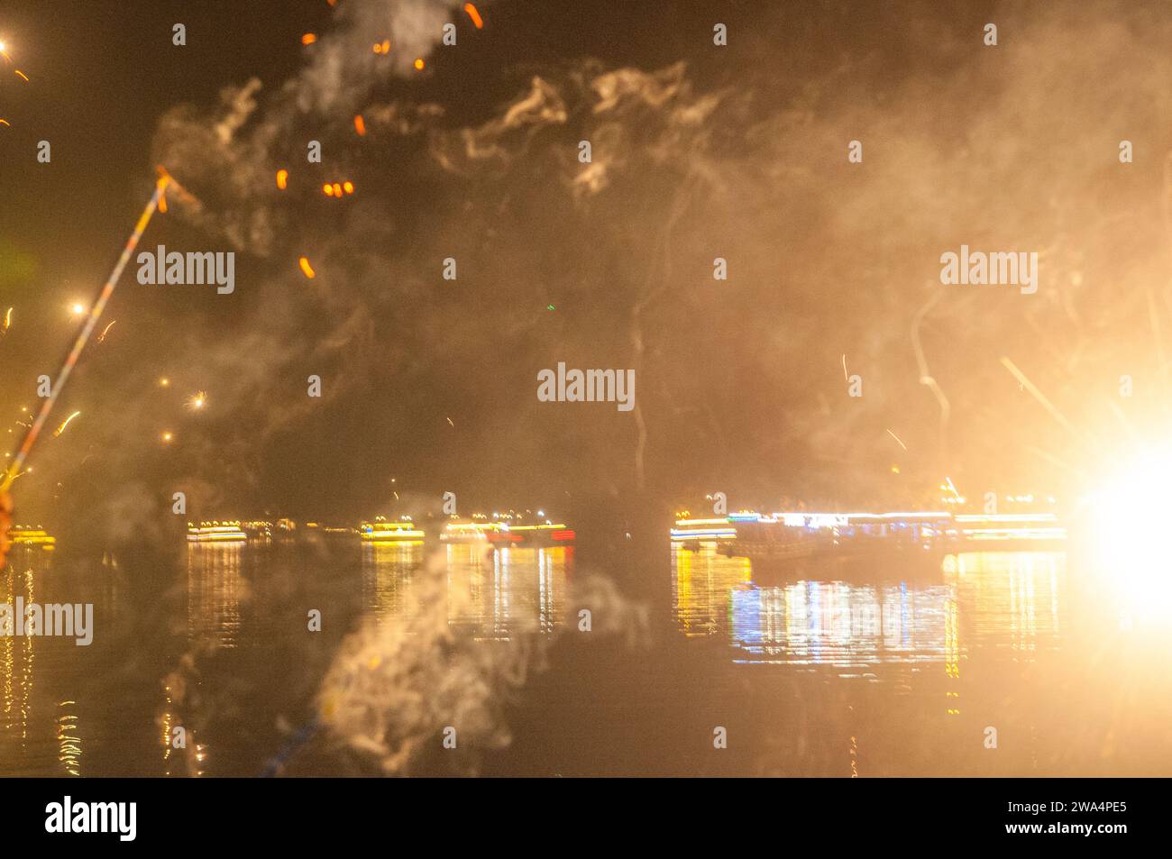 I festaioli sparano fuochi d'artificio a mezzanotte sul fiume Praek Tuek Chhu la vigilia di Capodanno dal 2023 al 2024. Kampot, Cambogia. © Kraig Lieb Foto Stock