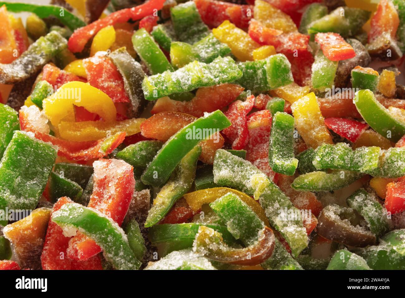 Peperone congelato a fette ricoperto di ghiaccio. Sfondo di verdure surgelate. Messa a fuoco selettiva. Foto Stock