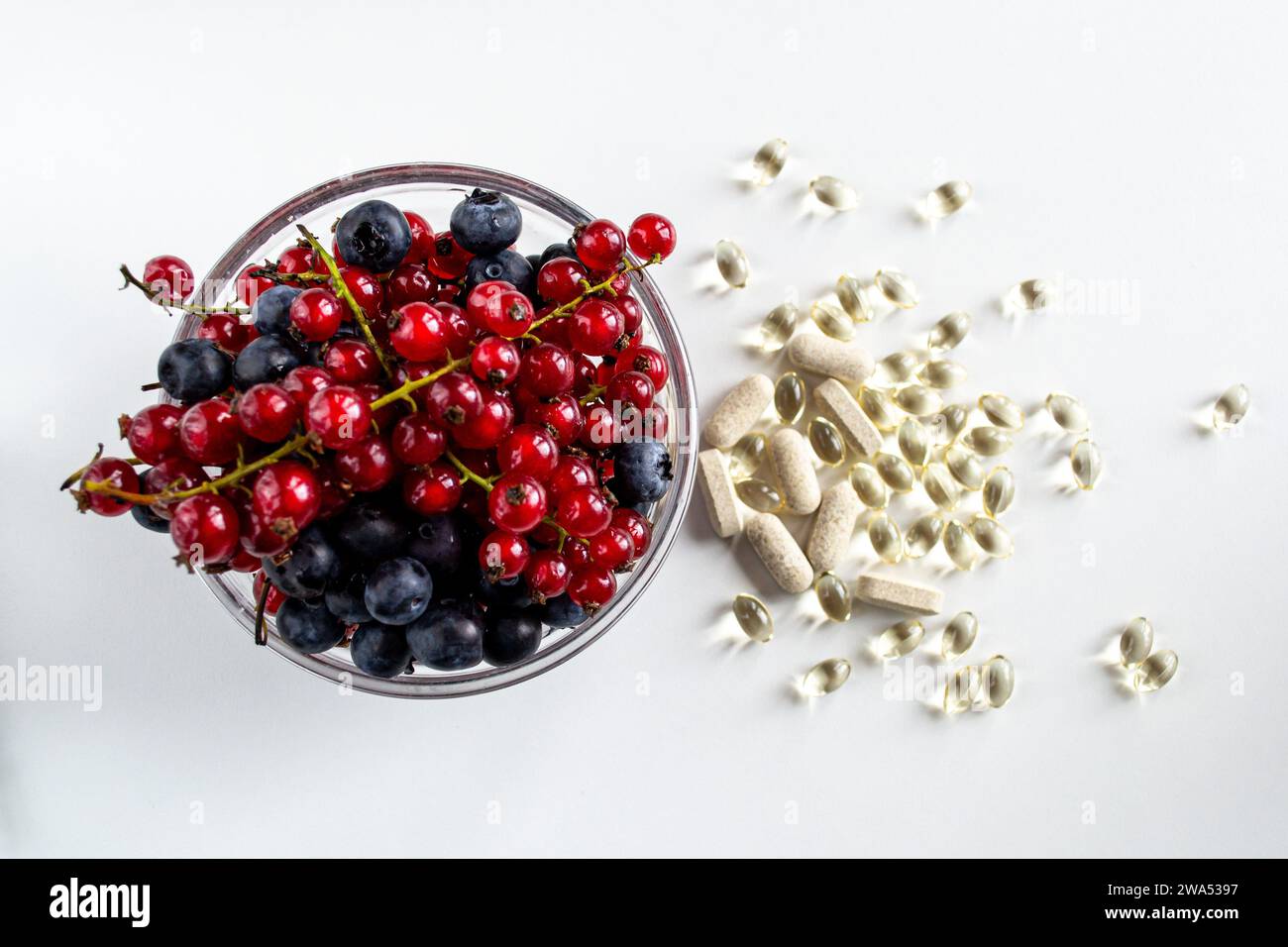 Ciotola con varietà di frutti di bosco e diversi tipi di vitamine Foto Stock