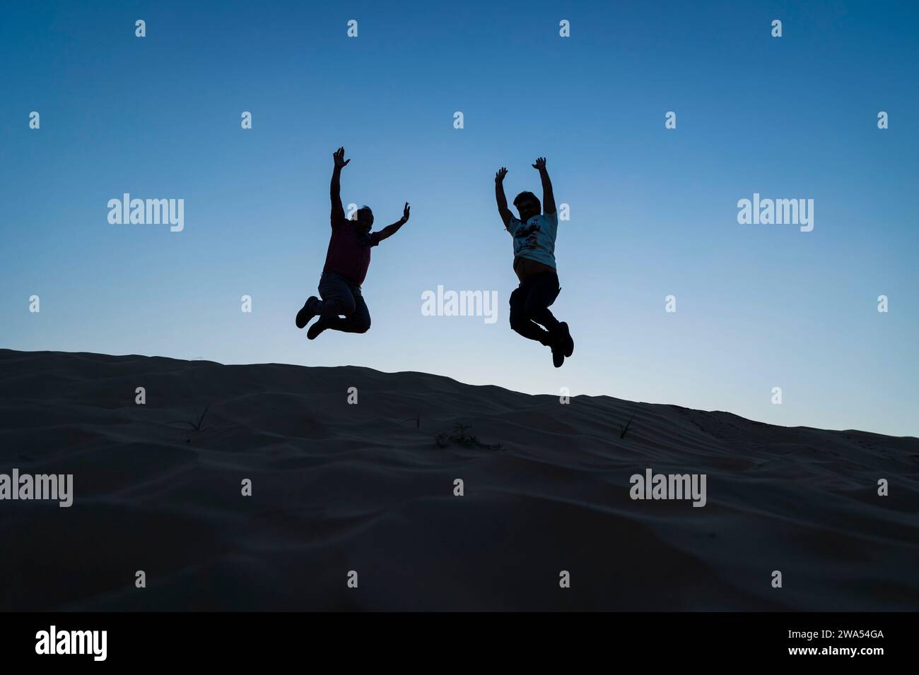 29 dicembre 2023, Dubai, Emirati Arabi Uniti. Gruppo di persone che saltano in alto sulle dune. Foto Stock