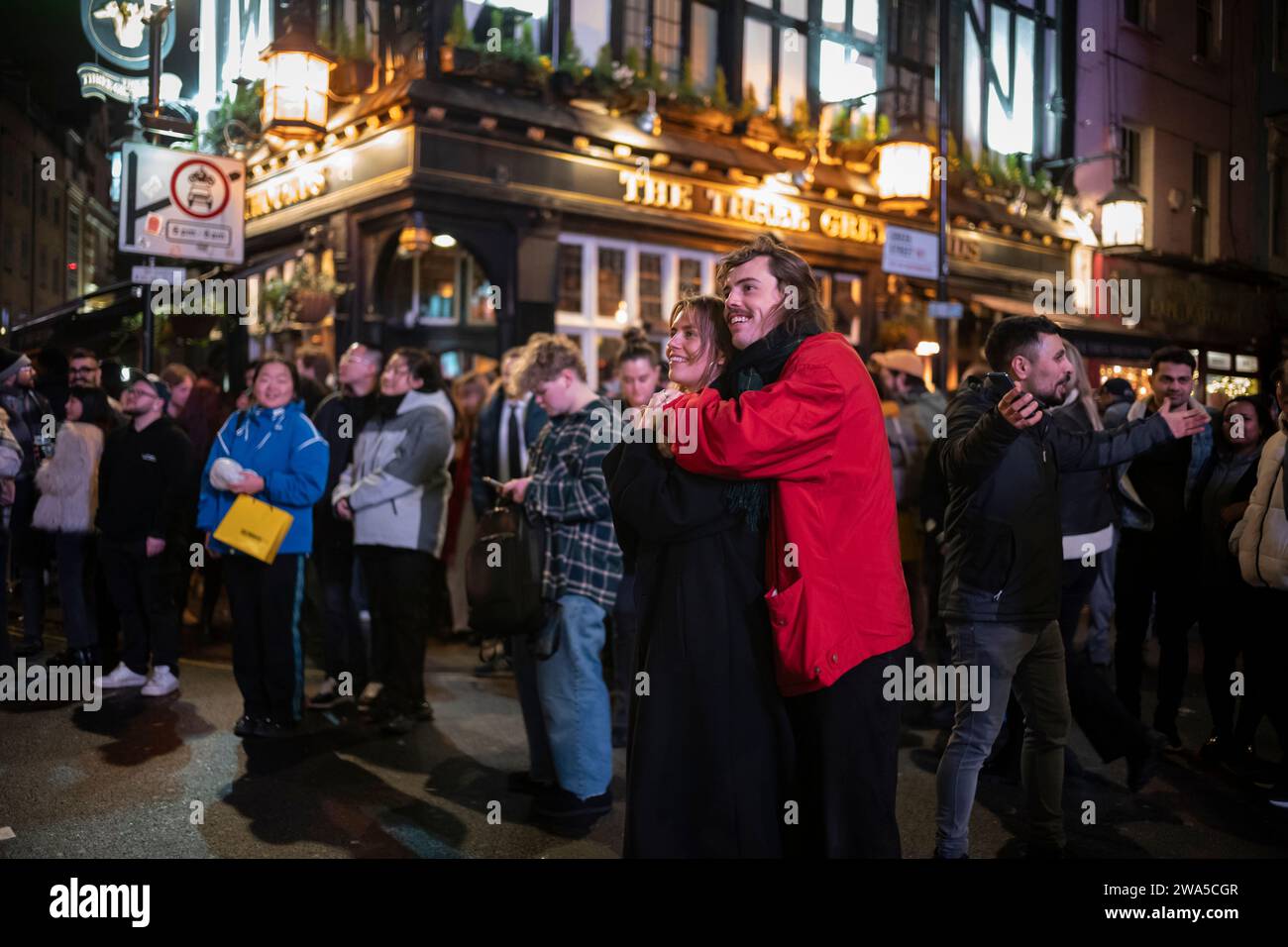 La gente apprezza l'atmosfera della festa di Capodanno mentre è in mezzo alla folla di Soho, la zona del West End della capitale, Londra, Inghilterra, Regno Unito. Foto Stock