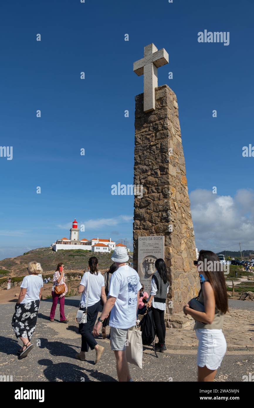 Cabo da Roca, Portogallo - persone al Monumento annunciano Cabo da Roca come il punto più occidentale dell'Europa continentale con il faro sullo sfondo. Foto Stock