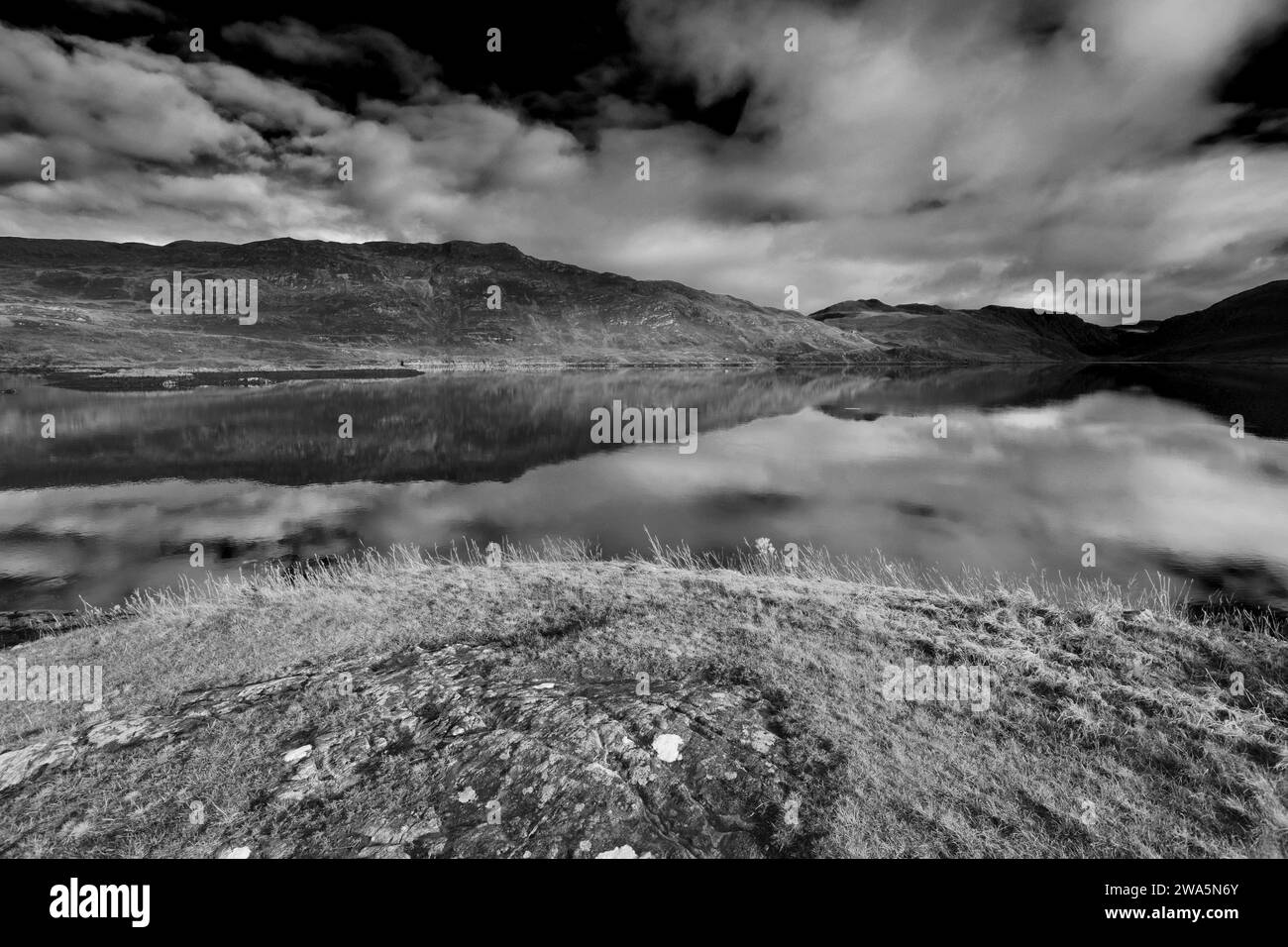 Riflessioni di montagna a Loch Gleann Dubh, villaggio di Kylesku, Sutherland, Scozia nord-occidentale, Regno Unito Foto Stock