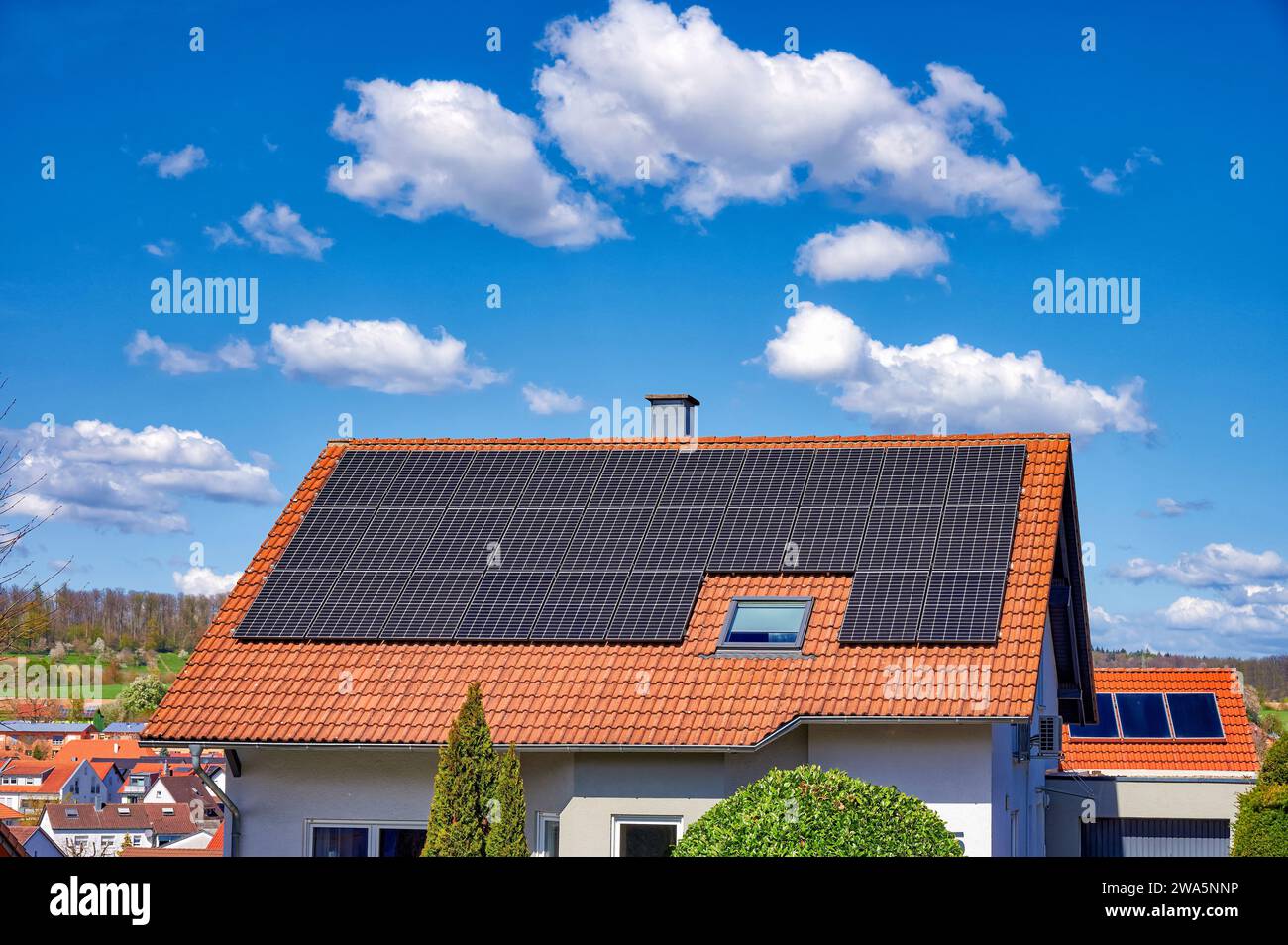 Uso di energia solare su edifici residenziali e un cielo blu brillante con nuvole bianche Foto Stock