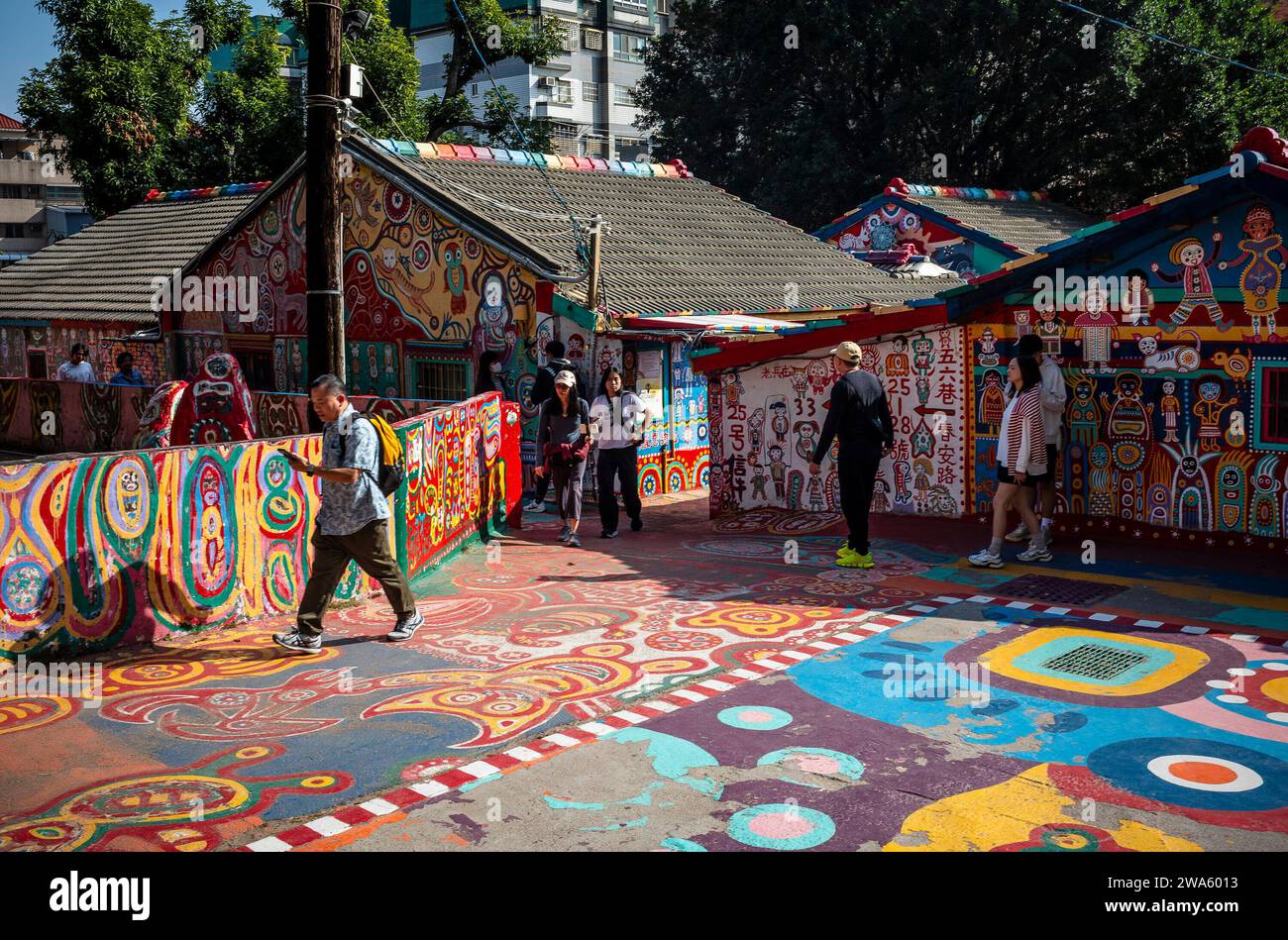 Taichung, Cina. 2 gennaio 2024. La gente interagisce con la vibrante Street art al Rainbow Village di Taichung, Taiwan il 02/01/2024 i colorati murales, creati da Huang Yung-fu, un ex soldato conosciuto come "Rainbow Grandpa", hanno trasformato un villaggio militare dipendente in una famosa destinazione d'arte, salvarlo dalla demolizione e catturare lo spirito della comunità con i suoi stravaganti dipinti. Il villaggio diventa una popolare attrazione turistica e serve allo stesso tempo un simbolo significativo del patrimonio locale e della resistenza creativa di Wiktor Dabkowski Credit: dpa/Alamy Live News Foto Stock