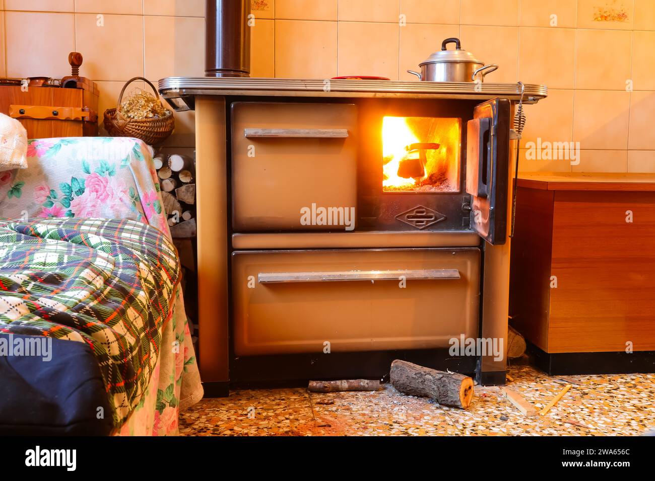 stufa a legna della cucina economica all'interno di una casa di montagna senza persone con il fuoco acceso Foto Stock