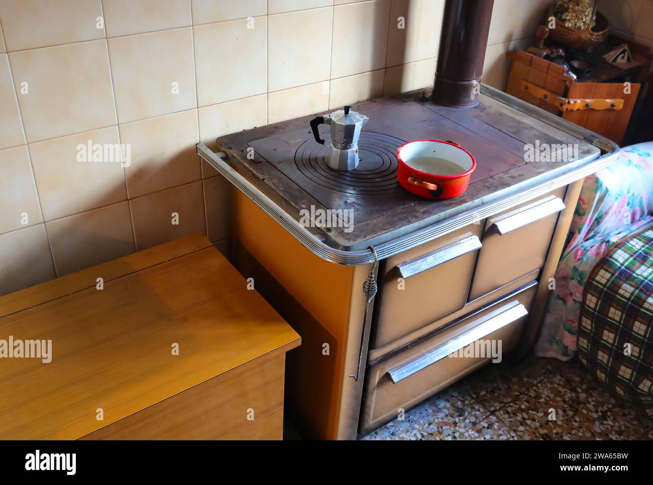 antica stufa a legna di una cucina economica con la moka per preparare il caffè a casa sulla piastra in ghisa calda Foto Stock