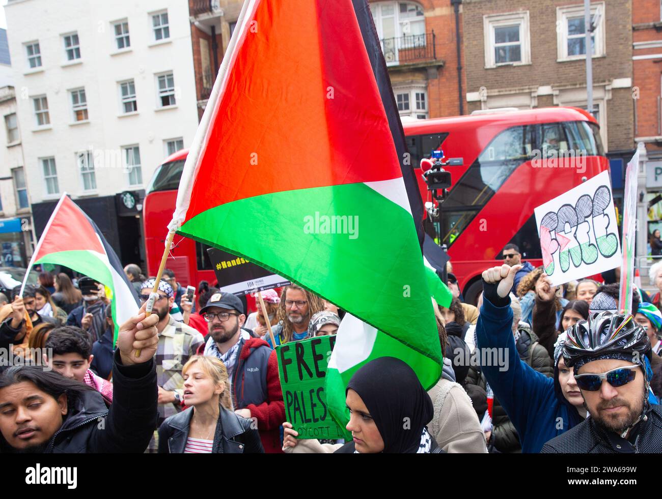 I manifestanti pro-palestinesi si riuniscono con bandiere e cartelli durante una protesta fuori dalle porte dell'ambasciata di Israele a Londra. Foto Stock