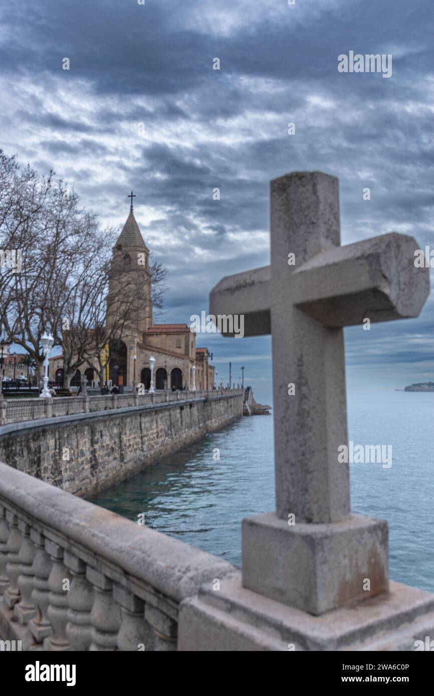 Prospettiva della chiesa di San Pedro sulla spiaggia di San Lorenzo a Gijon, da una delle croci del lungomare. Foto Stock