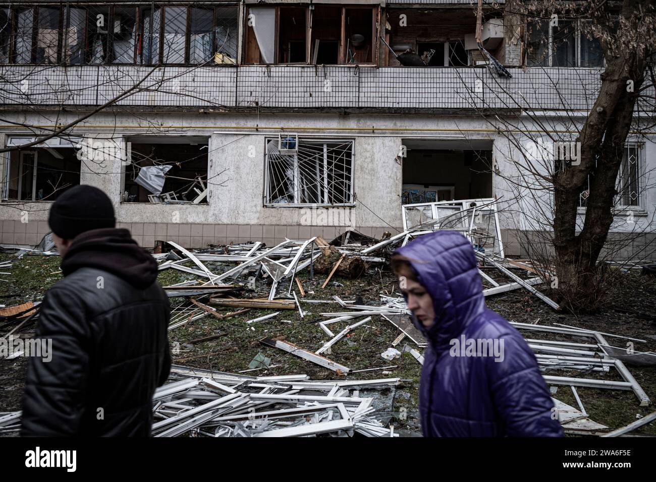 Kiev, Ucraina. 2 gennaio 2024. Nel quartiere residenziale di Solomyanka, un edificio di 9 piani con 10 gradini è stato colpito questa mattina presto. Due persone anziane sono state uccise e altri 49 residenti feriti.? I residenti passano davanti al loro edificio distrutto. Durante la notte, la Russia lanciò un grande attacco aereo contro l'Ucraina. Durante la notte la Russia lanciò un vasto attacco aereo contro l'Ucraina. Un'onda iniziale di 35 droni Shahed è stata lanciata alle 2. Crediti: LE PICTORIUM/Alamy Live News Foto Stock