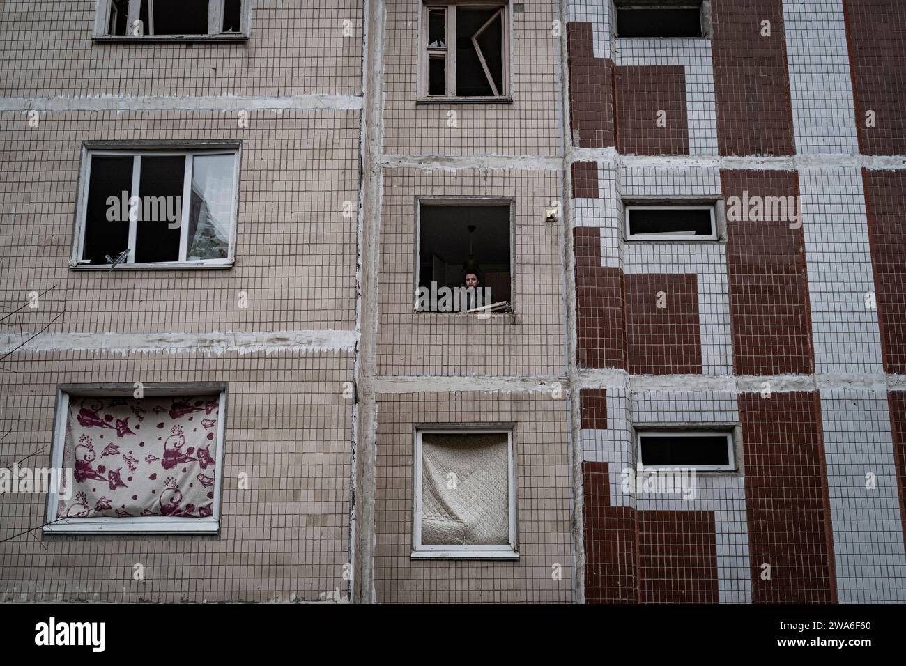 Kiev, Ucraina. 2 gennaio 2024. Nel quartiere residenziale di Solomyanka, un edificio di 9 piani con 10 gradini è stato colpito questa mattina presto. Due persone anziane sono state uccise e altri 49 residenti feriti.? Tre ore dopo lo sciopero, un residente riparò la finestra. Durante la notte, la Russia lanciò un grande attacco aereo contro l'Ucraina. A durante la notte la Russia lanciò un vasto attacco aereo contro l'Ucraina. Un'onda iniziale di 35 droni Shahed è stata lanciata alle 2. Crediti: LE PICTORIUM/Alamy Live News Foto Stock