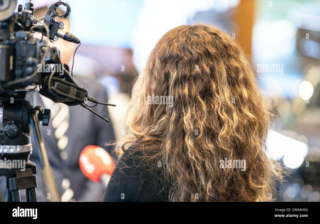 Giornalista televisiva femminile che tiene il microfono, fa un'intervista ai media Foto Stock