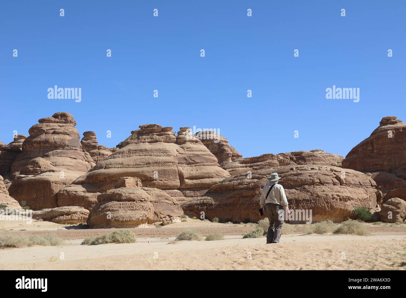 Geologo che esplora le formazioni rocciose nel deserto arabo Foto Stock