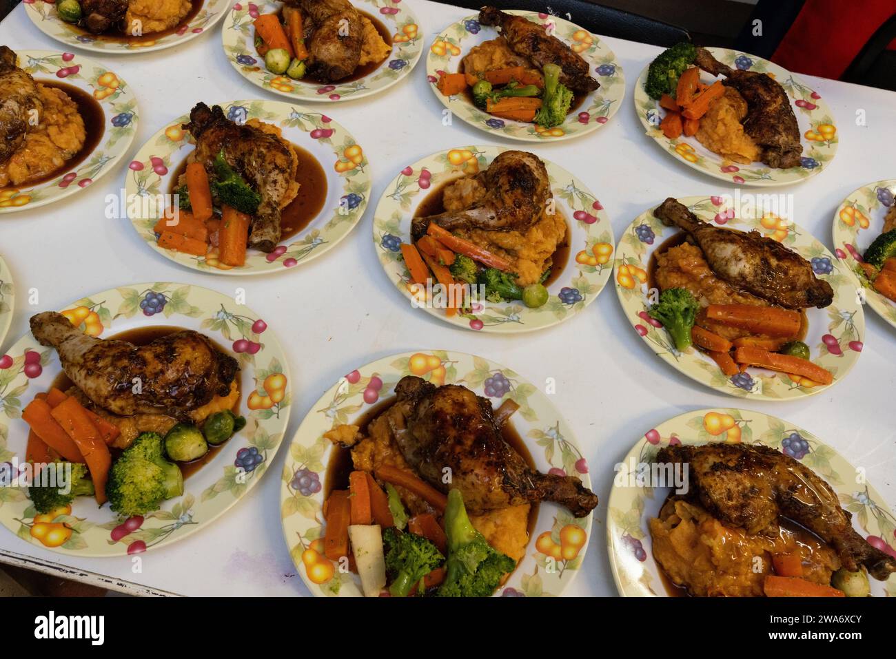 Piatti di cena di Natale preparati e pronti per essere serviti in una cucina comunitaria a Kilburn, Londra, con pollo arrosto e verdure. Foto Stock