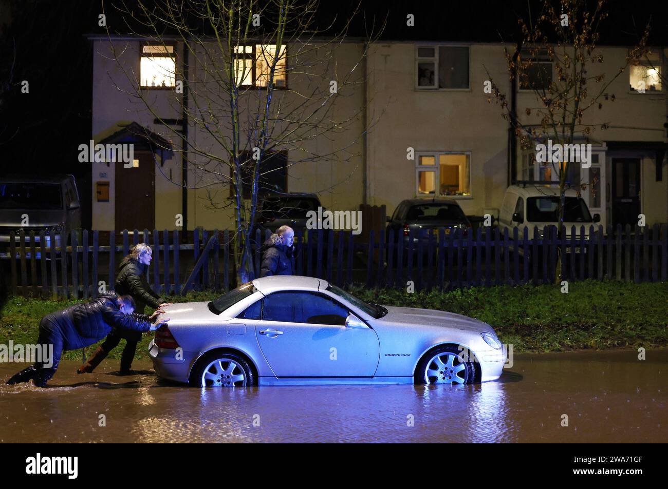 Hathern, Leicestershire, Regno Unito. 2 gennaio 2024. Meteo del Regno Unito. Gli automobilisti spingono un'auto dopo essere rimasti bloccati nell'acqua piena. Forti venti e pioggia battono un'ampia fascia del Regno Unito con la piccola ma potente tempesta Henk. Credit Darren Staples/Alamy Live News. Foto Stock