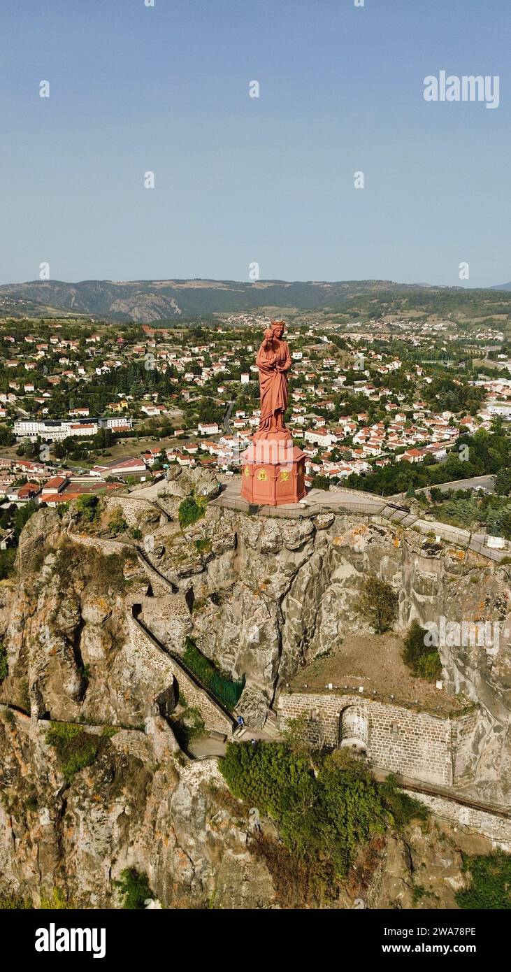 Riprese aeree con drone della Statue de Notre Dame de France Le Puy-en-Velay Francia, statua in ghisa rossa della Vergine Maria in cima al Rocher Corneille e veduta della città Foto Stock