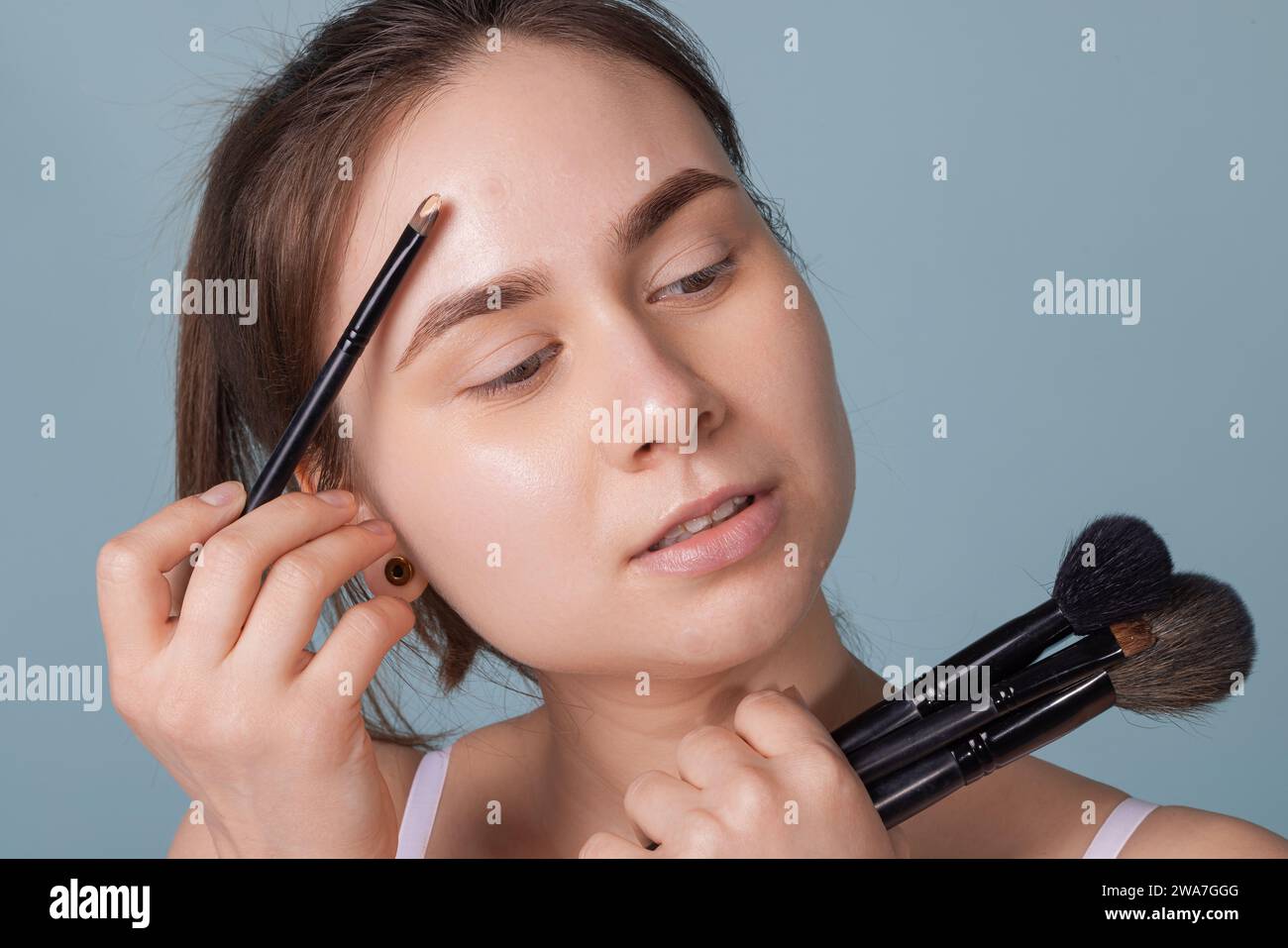 Una ragazza con l'acne attacca una patch sull'acne sulla guancia. Utilizzo di mini intonaco sul trucco Foto Stock