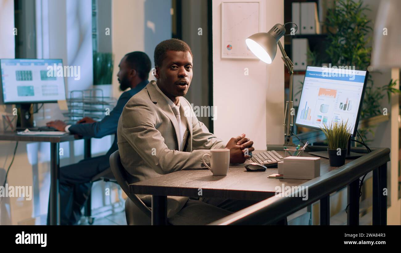 Manager afroamericano che fa video di formazione in ufficio per i nuovi dipendenti. Clip con istruzioni per la ripresa del supervisore per insegnare ai principianti aziendali le normali operazioni aziendali Foto Stock