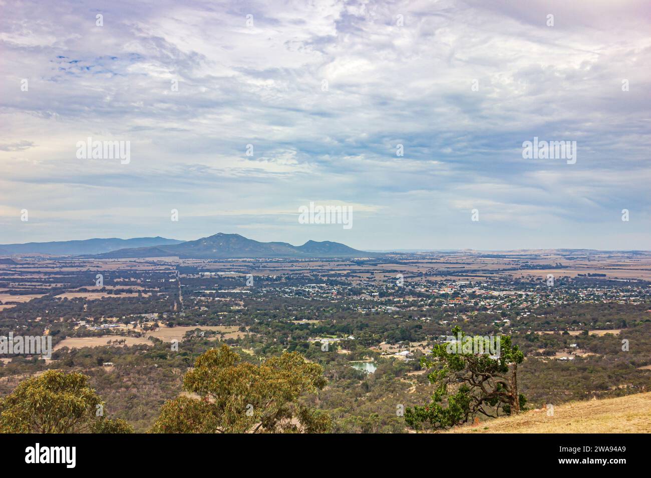 La vista di distese pianeggianti di terreni agricoli con la catena montuosa dei Grampians vista da One Tree Hill ad Ararat, una piccola cittadina nel Victoria, Australia. Foto Stock