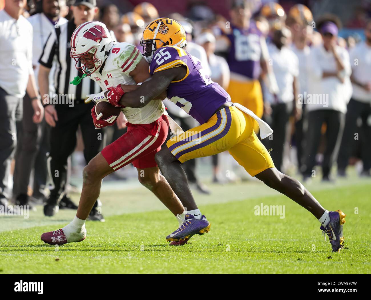 Il wide receiver dei Wisconsin Badgers Bryson Green (9) cerca di correre sul campo ma viene affrontato dal cornerback dei LSU Tigers Ashton Stamps (26) durante il quarto quarto quarto ReliaQuest Bowl tra Wisconsin vs LSU lunedì 1 gennaio 2024 al Raymond James Stadium di Tampa, Flag. LSU batte Wisconsin 35-31 (David Venezia / immagine dello sport) Foto Stock