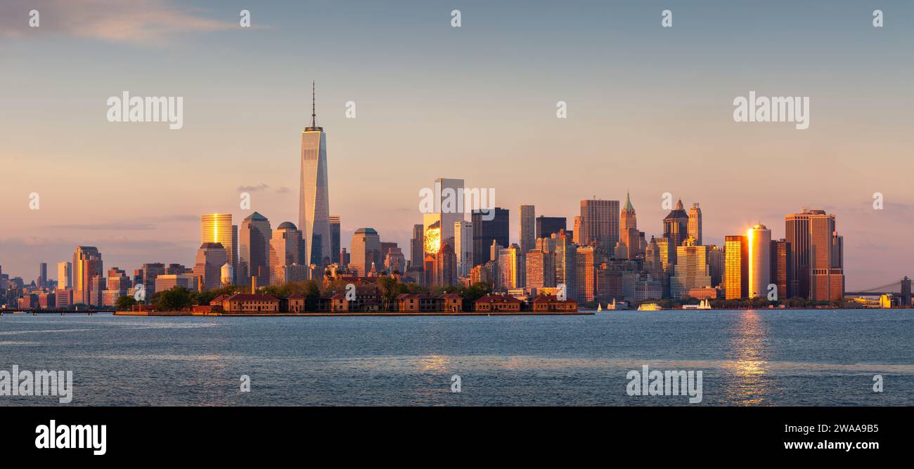 New York City Lower Manhattan grattacieli al tramonto. Vista panoramica dal porto di New York con il World Trade Center e gli edifici del quartiere finanziario Foto Stock