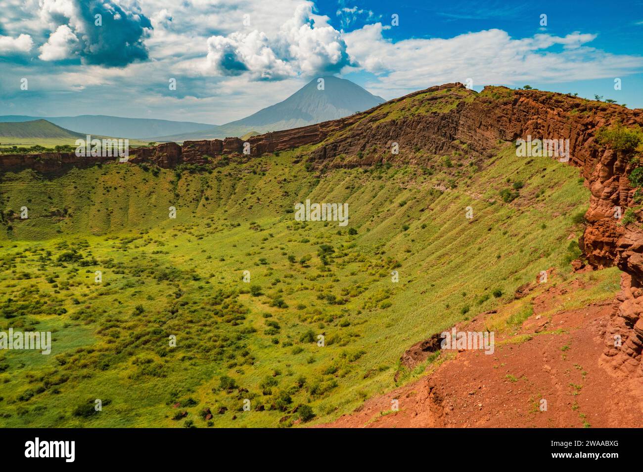 Shimo ya Mungu - Gods Pit ai margini dell'altopiano di Makonde con il Monte Ol Doinyo Lengai sullo sfondo nella Ngorongoro Conservation area in Tanzania Foto Stock