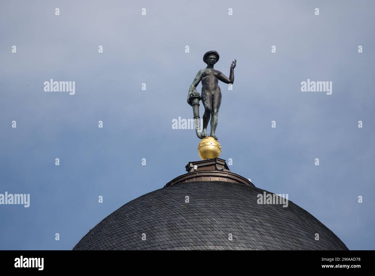 L'immagine mostra una statua dorata arroccata sulla cima di una cupola storica di Berlino, che incarna il ricco patrimonio culturale e l'espressione artistica della città. Foto Stock