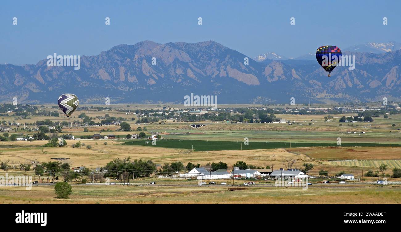 Mongolfiere di prima mattina che visitano le colline pedemontane della contea di Boulder in una soleggiata giornata estiva, con lo sfondo di una corsa frontale, come si vede da Broomfield, colorado Foto Stock