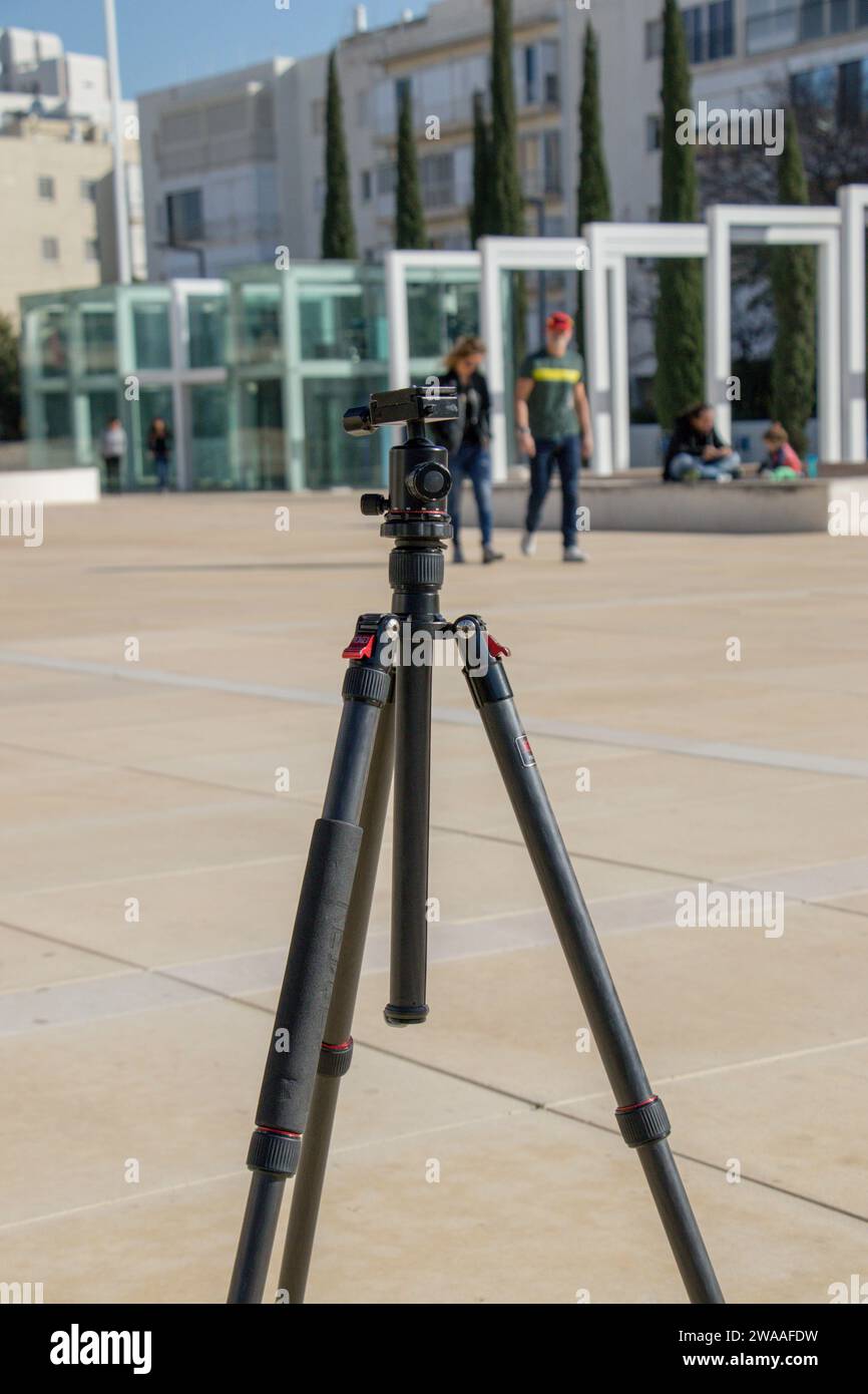 Un fotografo prepara il cavalletto, preparandosi a scattare in una giornata di sole. Foto Stock