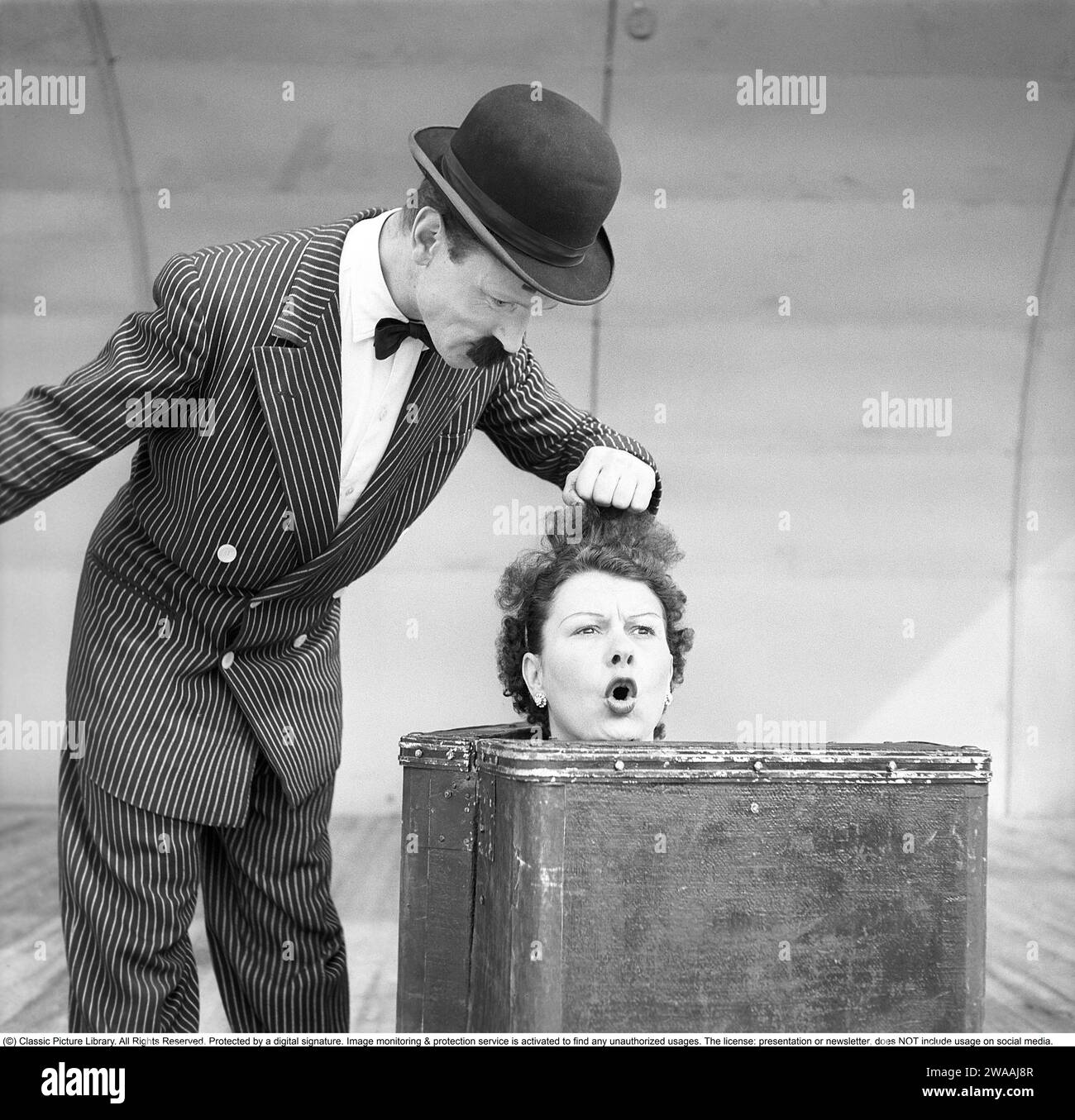 Prestazioni nel 1948. Gli artisti sotto il nome d'arte Arlington si esibiscono sul Main Stage. Lui indossa un vestito, un cappello e un finto baffo incollato e lei con solo la testa visibile da una valigia. Rif. Conard 980 Foto Stock
