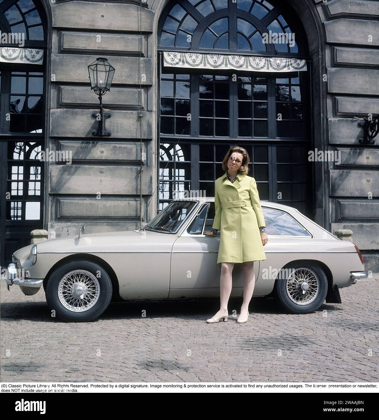 Principessa Christina, signora Magnuson. Sorella del re svedese Carl XVI Gustaf. Nato il 3 agosto 1943. L'auto che ha due anni qui è una MG MGB, un'auto sportiva nel colore Sany Beige, prodotta dalla casa automobilistica britannica MG tra il 1962 e il 1980. Era disponibile come cabriolet e con una carrozzeria coperta a 2+2 posti (GT). Le versioni a sei cilindri prodotte a partire dal 1967-69 furono chiamate MGC. Fotografato all'esterno del Palazzo reale di Stoccolma il 2 giugno 1969 in un vestito d'epoca. Foto Stock