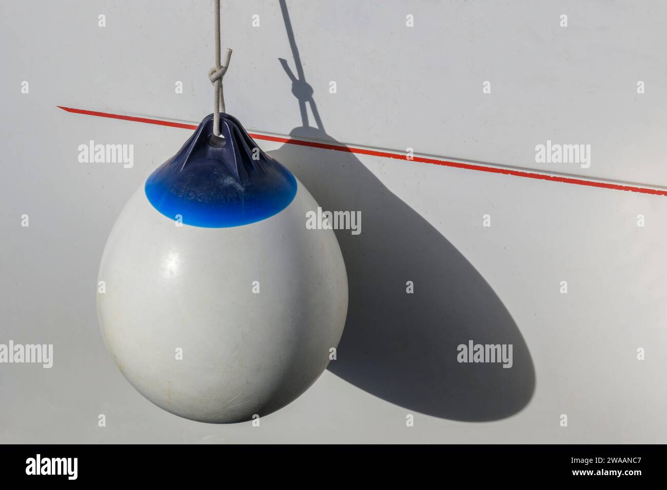 Grande parafango rotondo a bordo dello yacht a vela, bianco e blu con ombra. Protettore. Concetto di yachting. Foto Stock