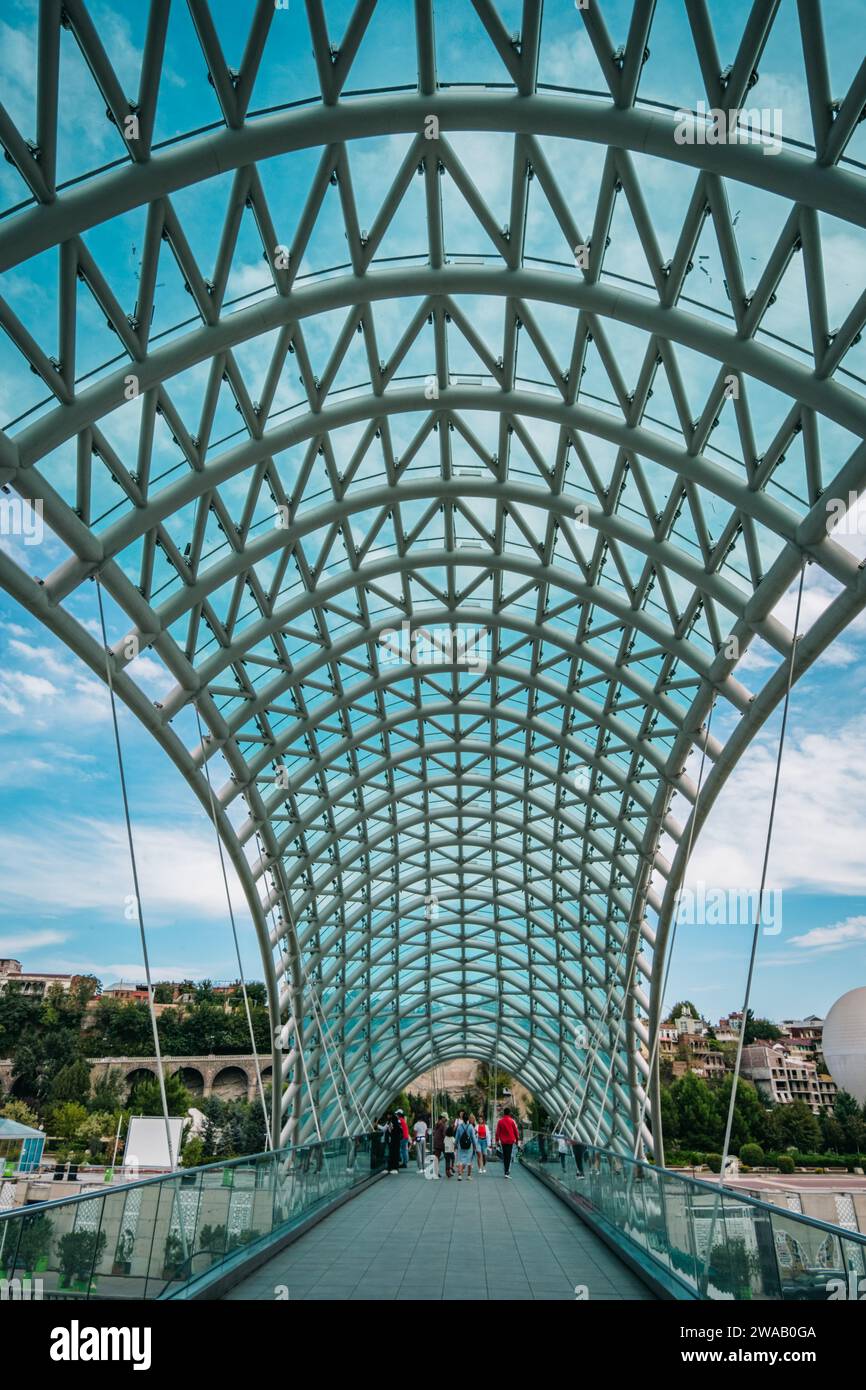 Sotto il tetto di vetro del Ponte della Pace che attraversa il fiume Kura nella città vecchia di Tbilisi, Georgia Foto Stock
