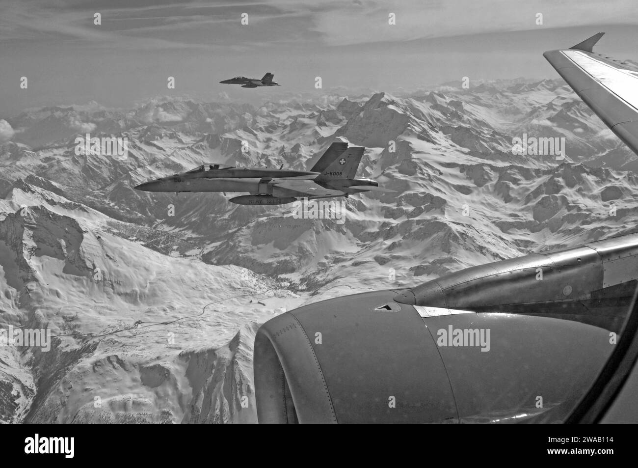 FA-18 jet militari da Swiss Airforce scortando airplaine civile nelle alpi svizzere Foto Stock