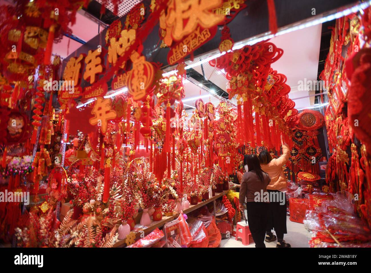 SHENYANG, CINA - 3 GENNAIO 2024 - le persone acquistano distici, lanterne e bambole per la festa di primavera in un mercato all'ingrosso a Shenyang, nel nord-est della Cina Foto Stock