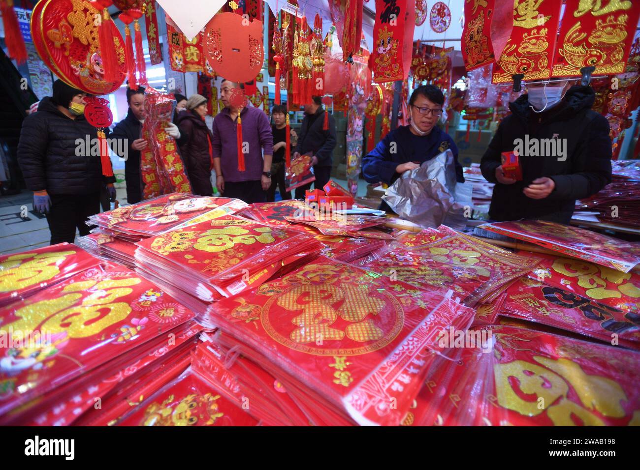 SHENYANG, CINA - 3 GENNAIO 2024 - le persone acquistano distici, lanterne e bambole per la festa di primavera in un mercato all'ingrosso a Shenyang, nel nord-est della Cina Foto Stock