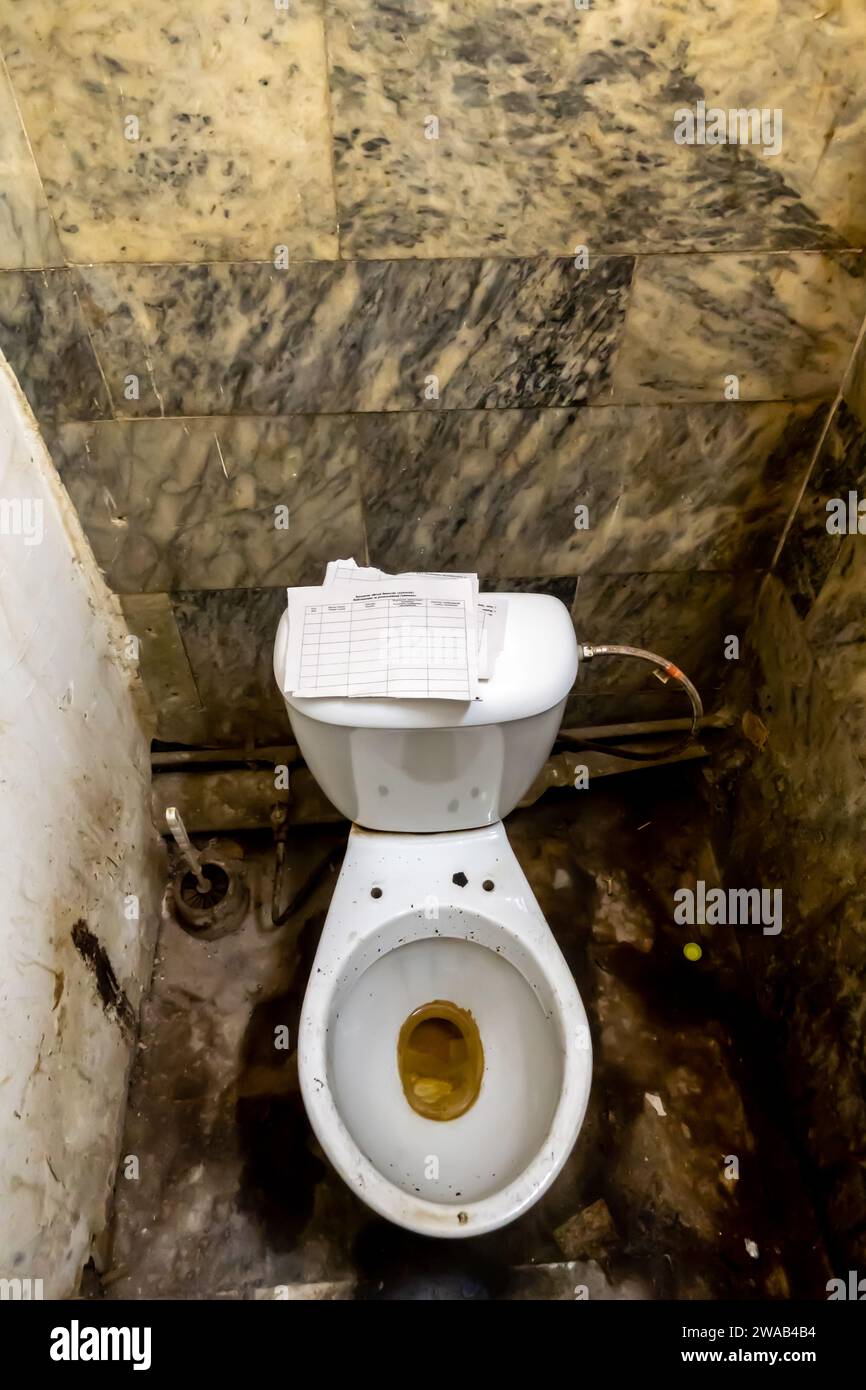 La disposizione dei servizi igienici del bagno era tipica dei servizi igienici pubblici dell'epoca sovietica, con carta strappata come carta igienica Foto Stock