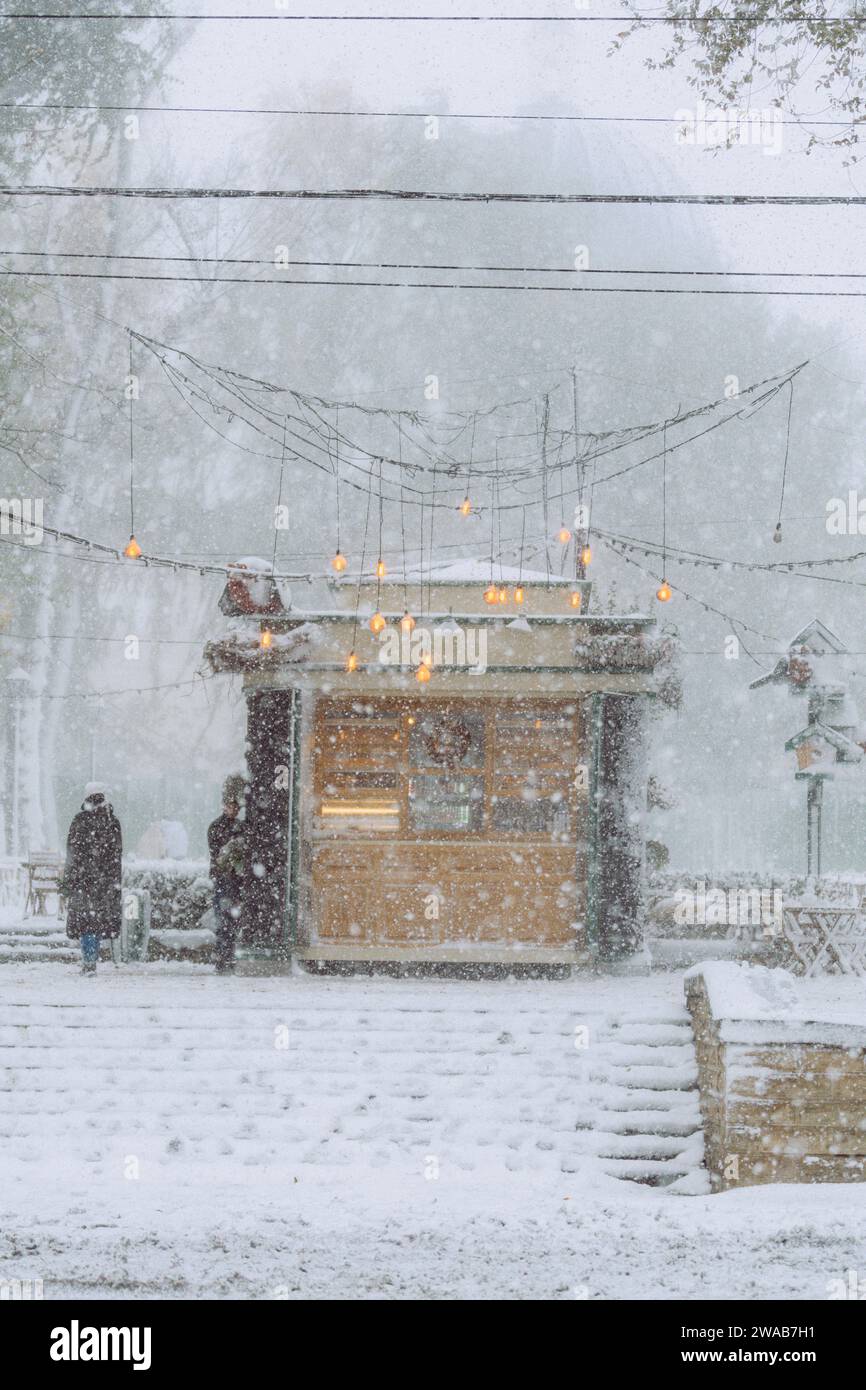 Pasticceria del centro città illuminata durante le tempeste di neve Foto Stock