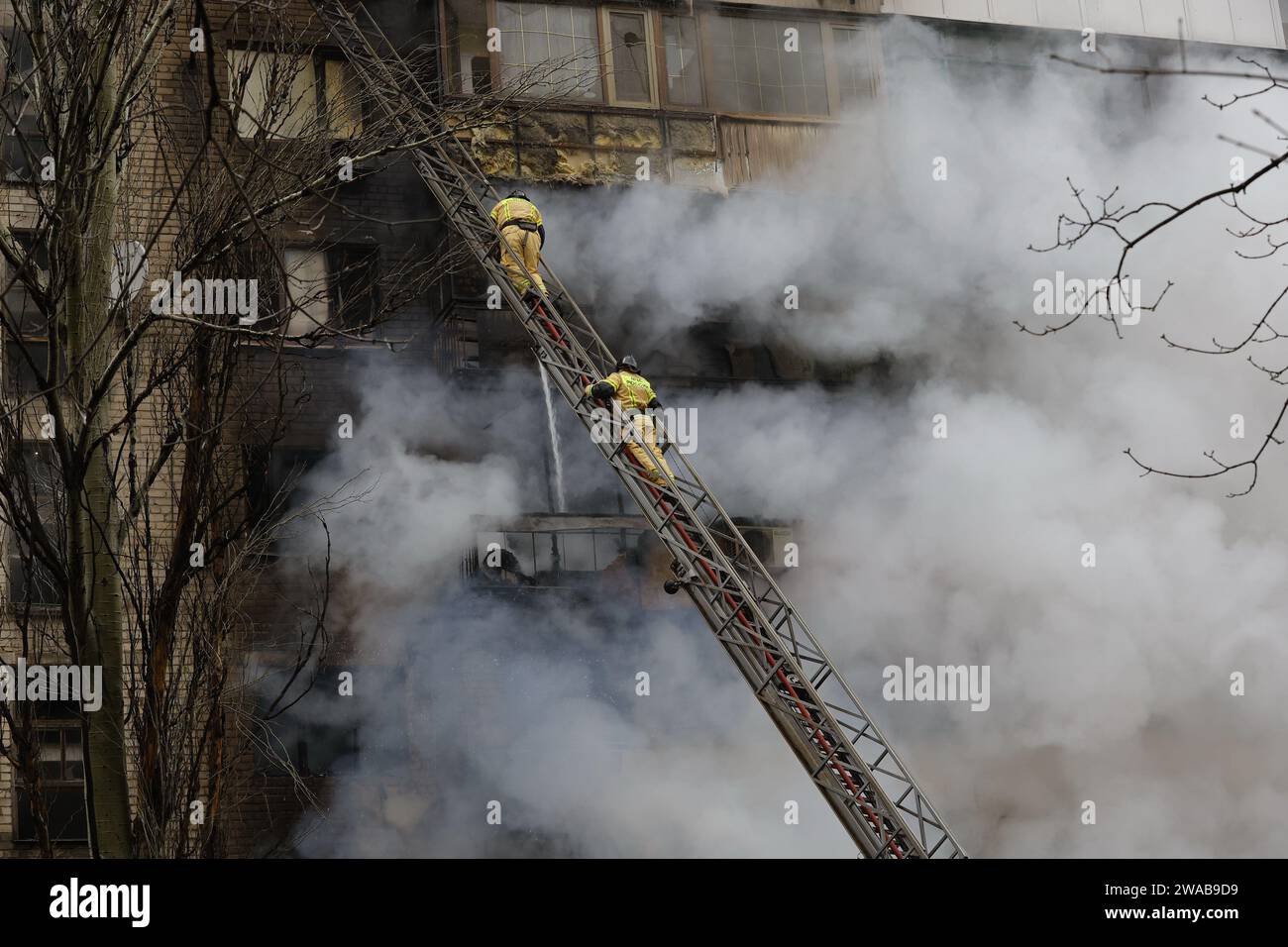 (240103) -- PECHINO, 3 gennaio 2024 (Xinhua) -- i vigili del fuoco spengono il fuoco in un edificio danneggiato colpito da recenti bombardamenti a Donetsk, 19 dicembre 2023. (Foto di Victor/Xinhua) Foto Stock